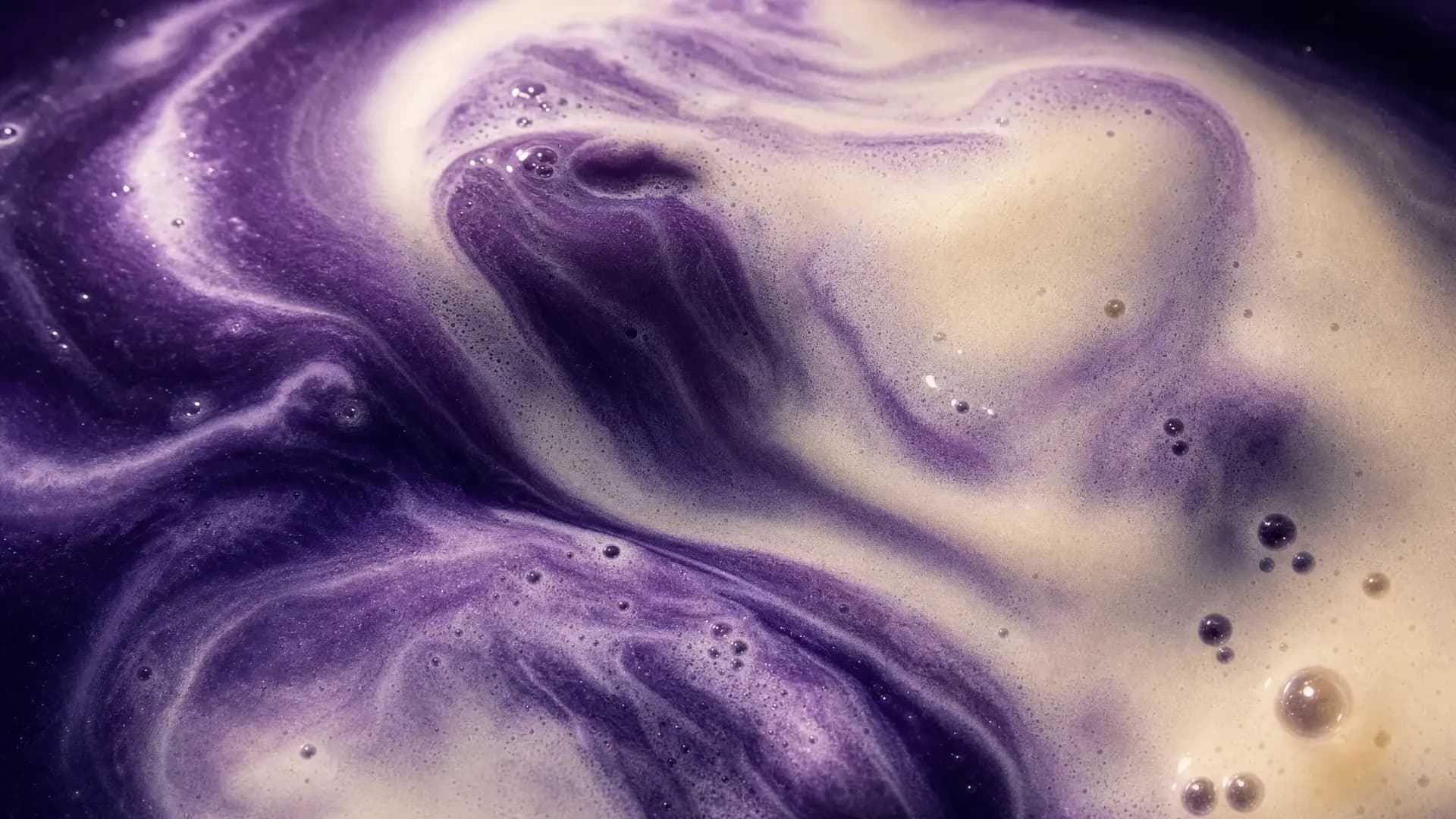 Close-up van paarse ube die wervelt door melk.