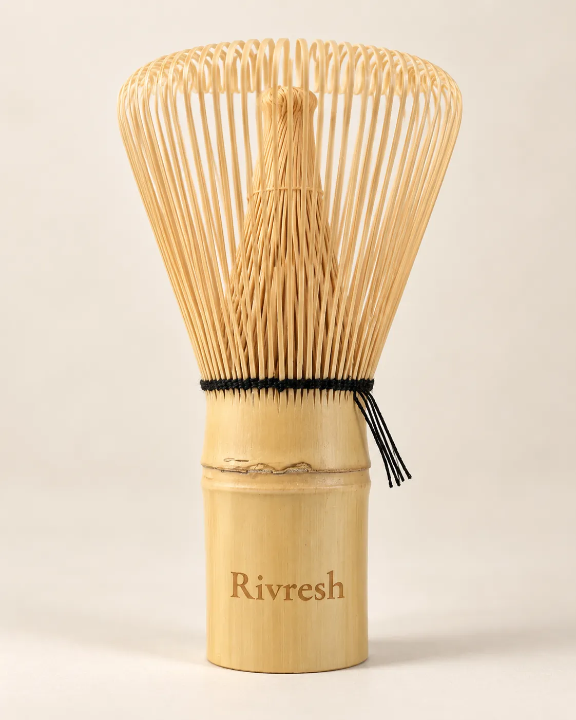 Bamboe matcha-garde met Rivresh in het handvat gegraveerd, op een crème achtergrond.