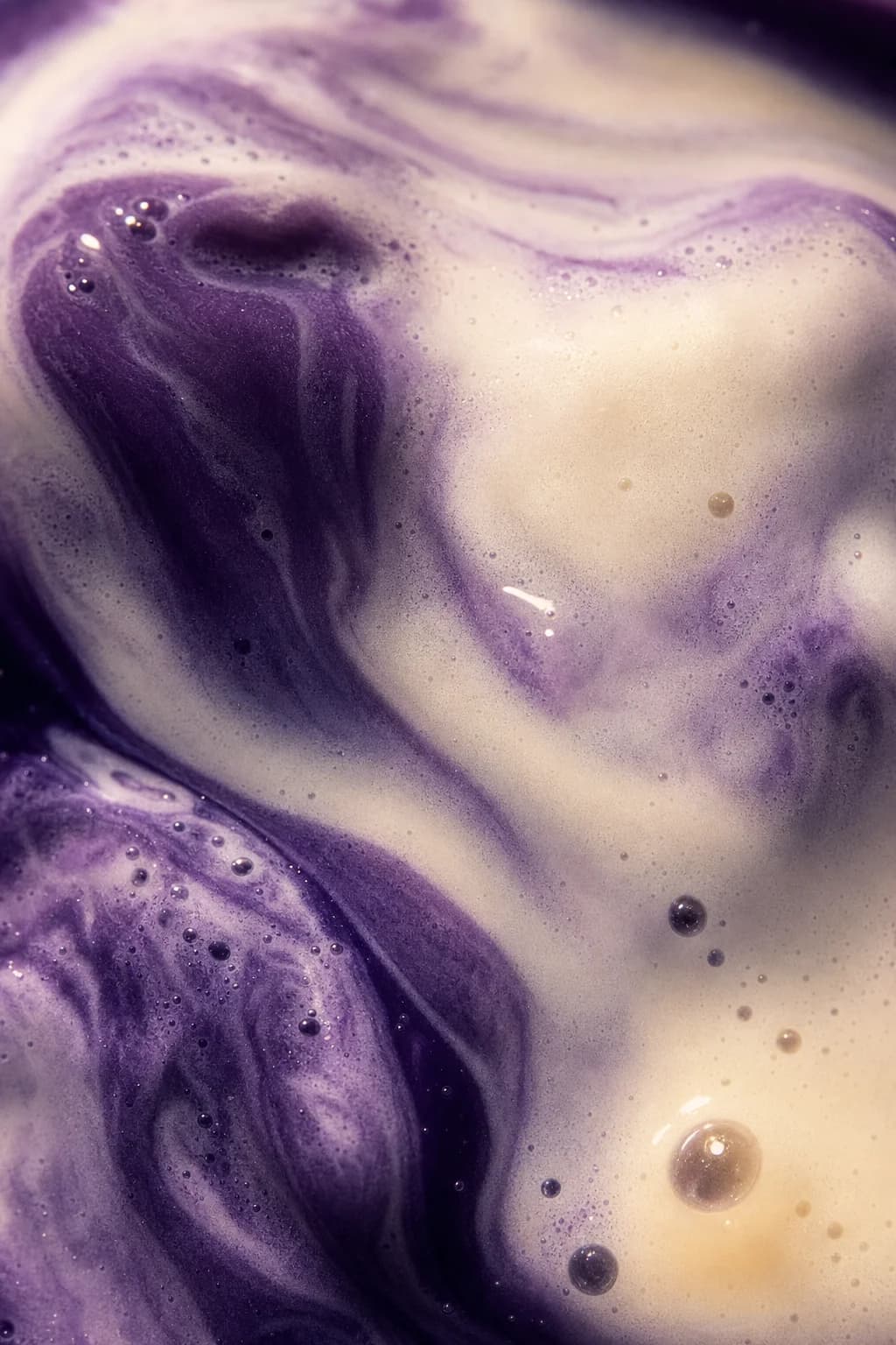 Close-up van paarse ube die wervelt door melk.